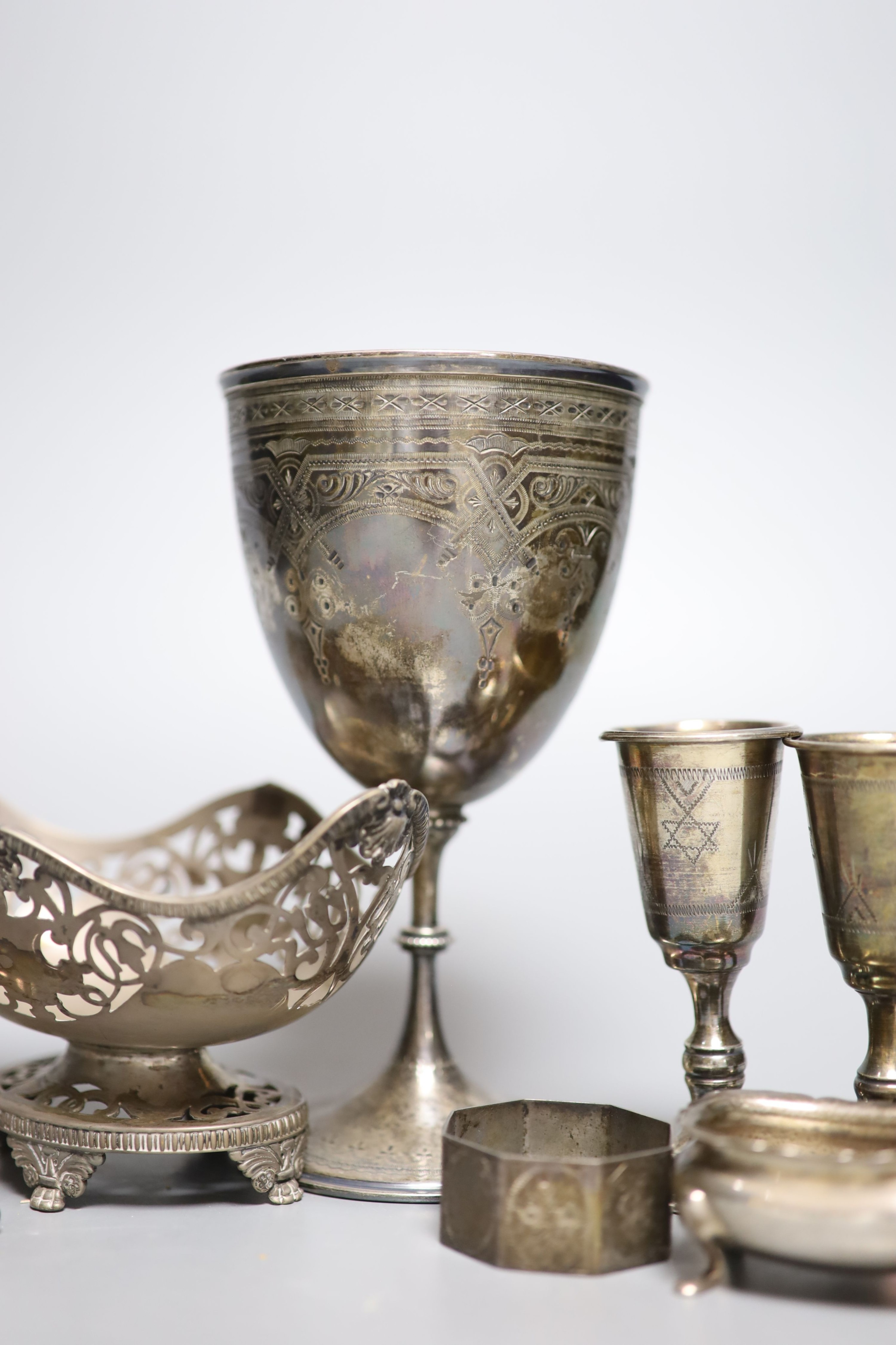 Five George V silver kiddush cups, a late Victorian silver goblet, a silver bonbon dish, silver salt, silver napkin ring and a plated sugar shovel